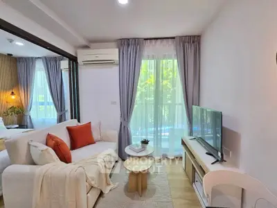 Charming living room with cozy sofa, modern decor, and natural light from large windows.