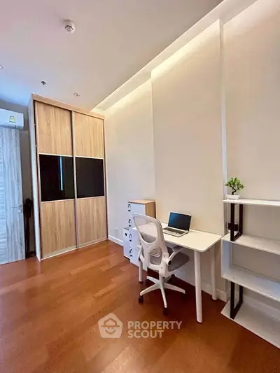Modern study room with sleek desk, ergonomic chair, and built-in wooden wardrobe.