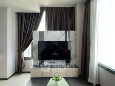 Modern living room with stylish TV setup and elegant curtains, perfect for urban living.