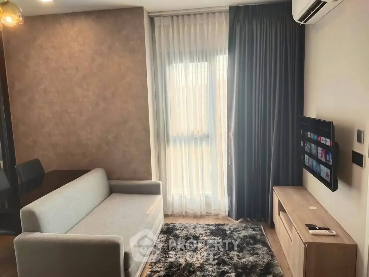 Modern living room with cozy sofa, wall-mounted TV, and elegant curtains