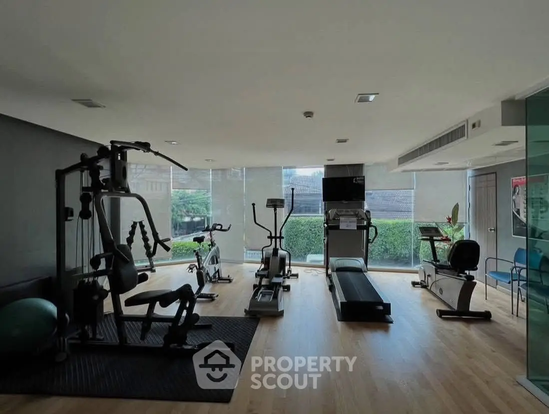 Modern gym with state-of-the-art equipment and large windows offering a scenic view.