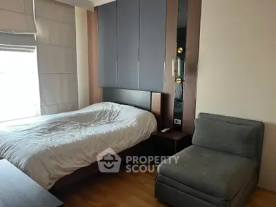 Cozy bedroom with modern decor and natural light, perfect for relaxation.