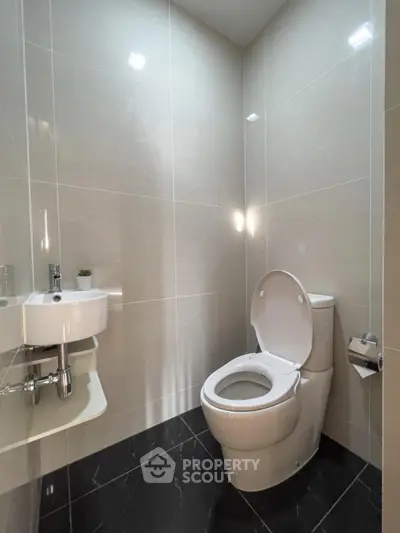 Modern minimalist bathroom with sleek fixtures and glossy tiles