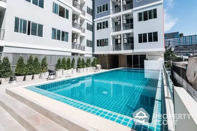 Modern apartment building with a luxurious outdoor swimming pool and stylish design.