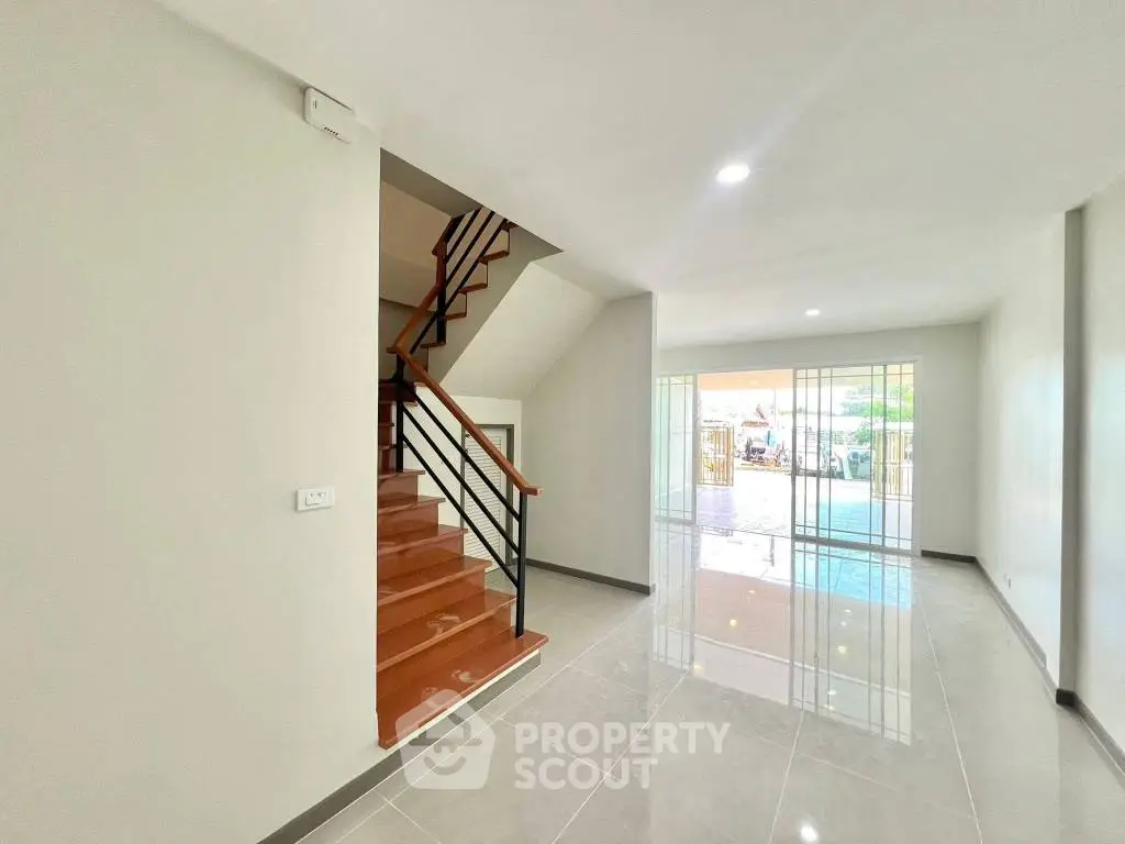 Spacious modern living room with sleek staircase and large windows
