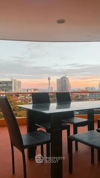 Stunning balcony with panoramic city view and modern outdoor dining set.