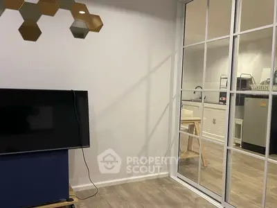 Modern living room with TV and view into stylish kitchen