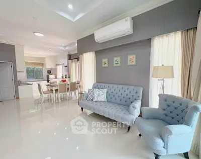 Spacious open-plan living room with elegant furniture and modern kitchen, perfect for family gatherings.