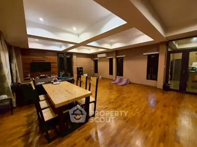 Spacious open-plan living room with wooden flooring and modern dining area