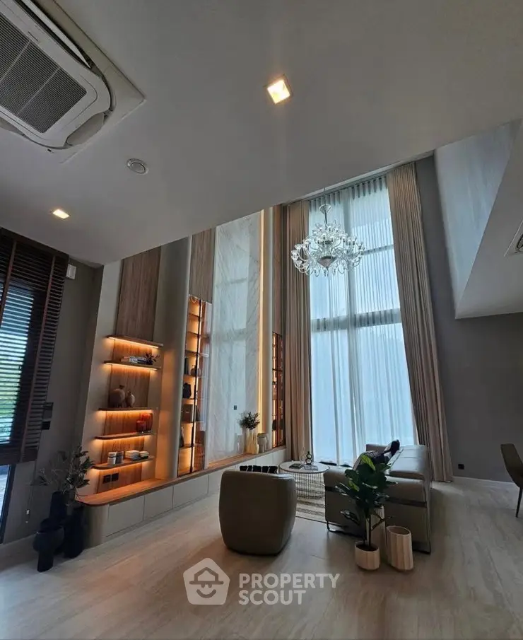 Luxurious modern living room with high ceilings and elegant chandelier