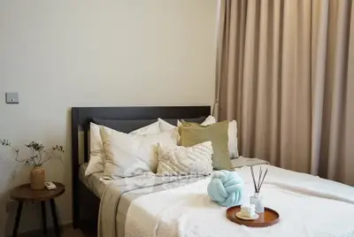 Cozy bedroom with stylish decor and plush bedding in modern apartment.