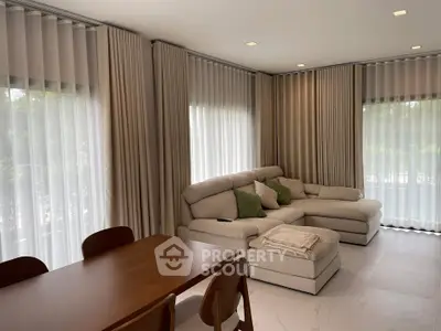 Spacious living room with elegant curtains and cozy sectional sofa, perfect for relaxation and entertaining.