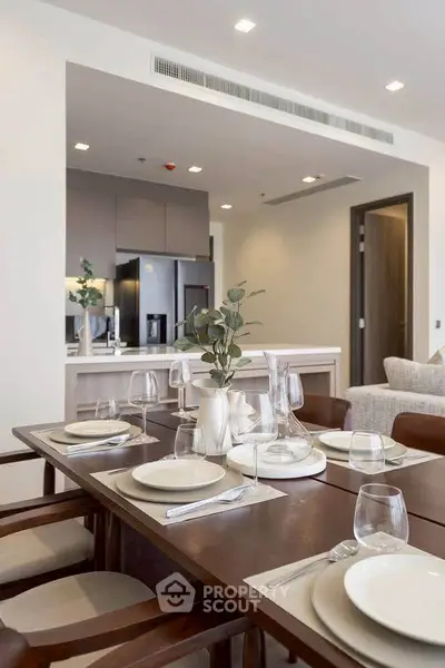 Modern dining area with elegant table setting and open kitchen layout