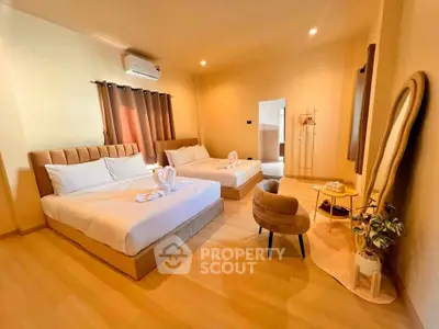 Spacious bedroom with two beds, elegant decor, and natural lighting for a cozy living experience.