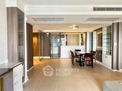 Spacious open-plan living and dining area with modern kitchen in luxury apartment.