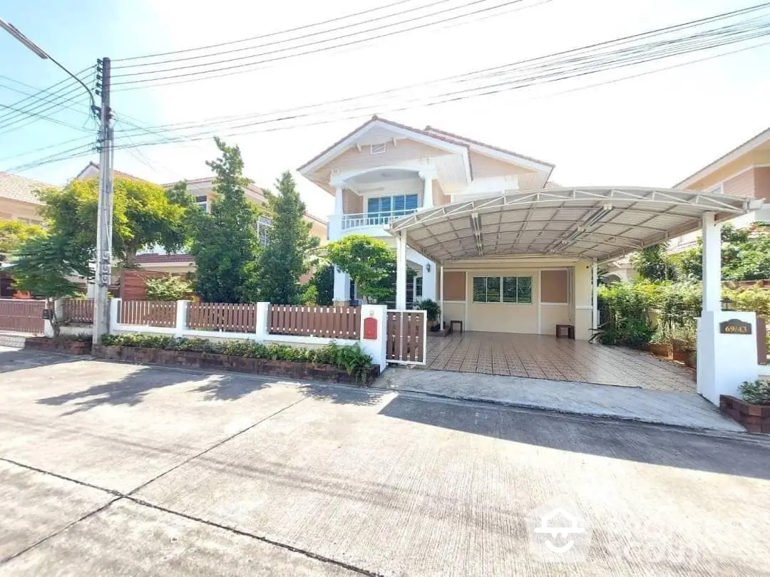 Spacious two-story home with covered parking, lush greenery, and a welcoming entrance, in a serene neighborhood.