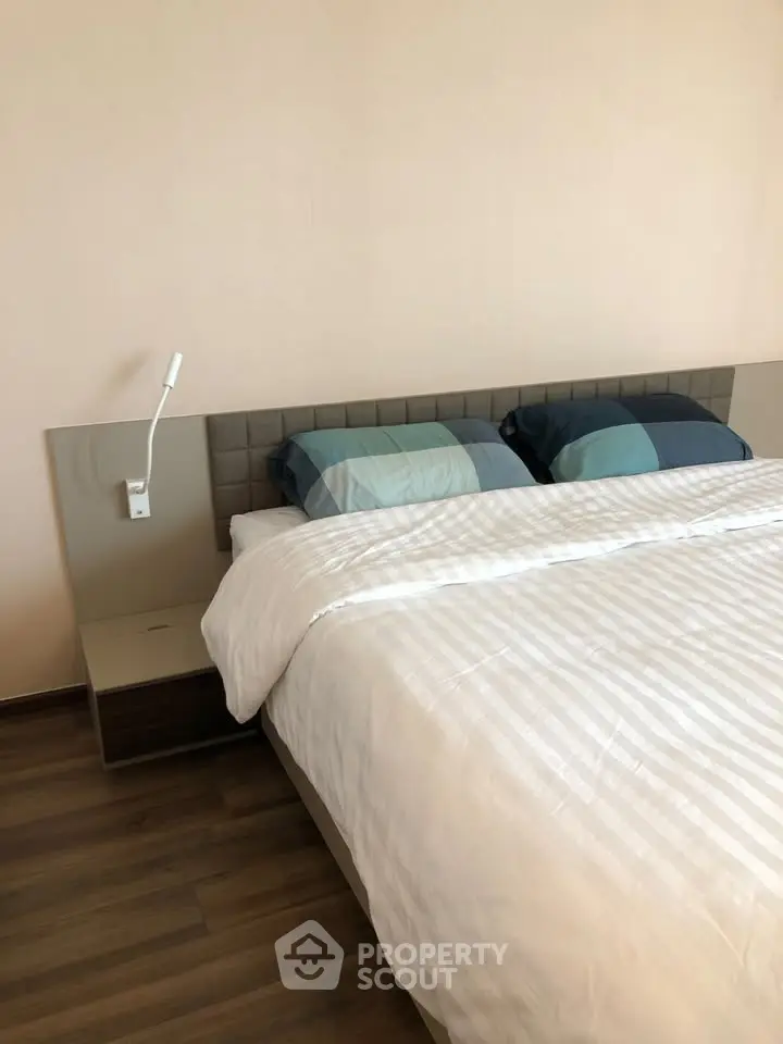 Modern bedroom with stylish bed and wooden flooring, perfect for a cozy retreat.