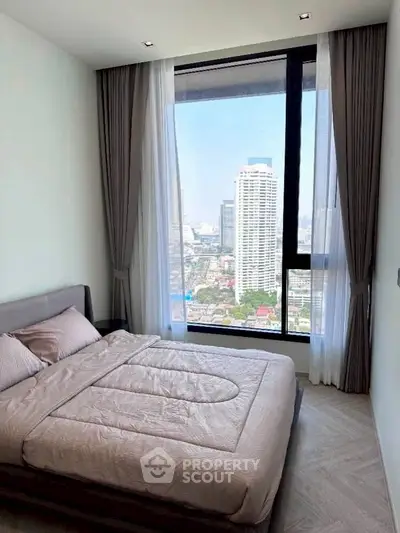 Modern bedroom with stunning city view from large window, featuring elegant curtains and cozy bedding.