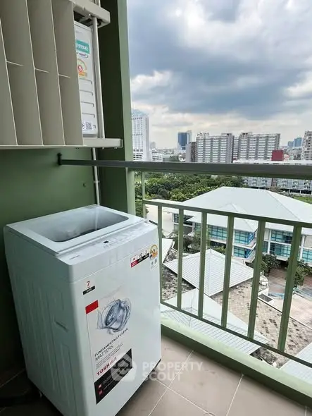 Balcony with washing machine and city view, ideal for urban living convenience.