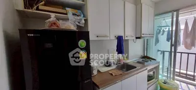 Compact kitchen with balcony access in modern apartment