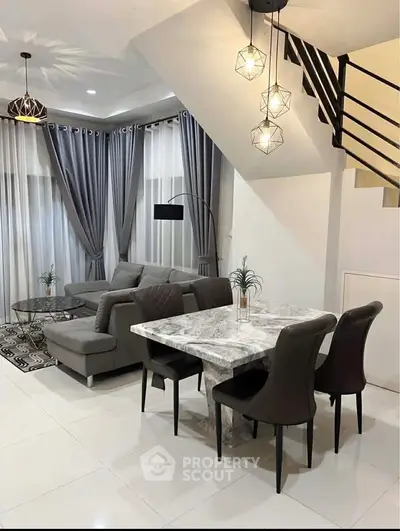 Modern living room with elegant dining area and stylish lighting fixtures.