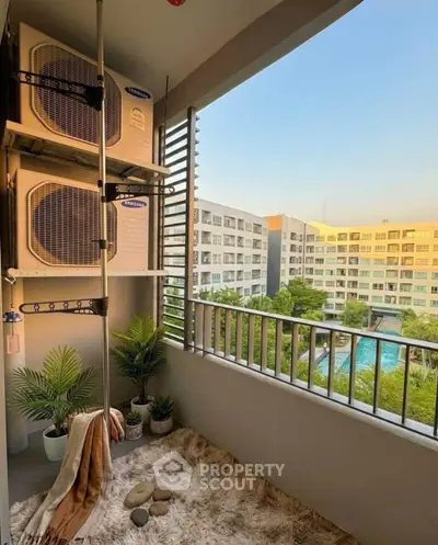 Charming balcony with air conditioning units and a serene view of a residential complex and pool.