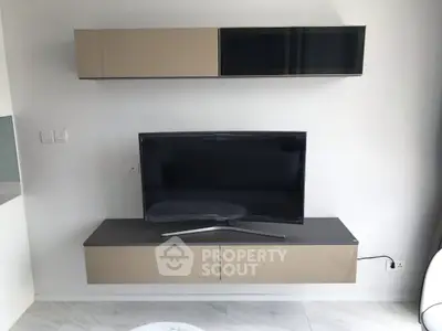 Modern living room with sleek wall-mounted TV and stylish storage cabinets.