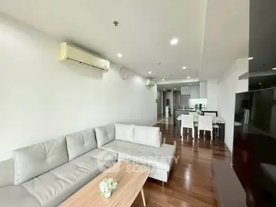 Spacious modern living room with sleek furniture and open kitchen layout