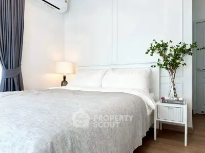 Cozy bedroom with elegant decor and natural light, featuring a comfortable bed and stylish nightstand.