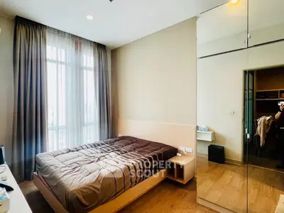 Modern bedroom with large window and mirrored wardrobe in stylish apartment