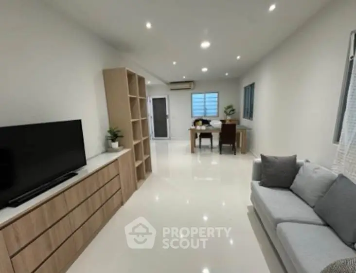 Spacious modern living room with sleek furniture and ample natural light.