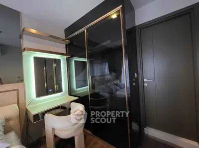 Modern bedroom with sleek black wardrobe and illuminated vanity mirror