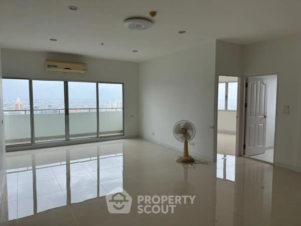 Spacious unfurnished living room with large windows and city view