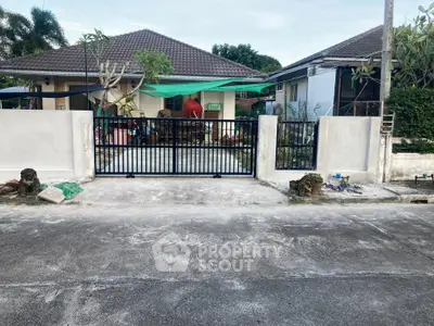 Charming suburban house with gated entrance and lush greenery, perfect for family living.
