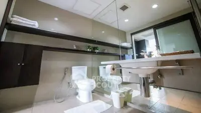 Modern bathroom with sleek fixtures and large mirror in a contemporary home.