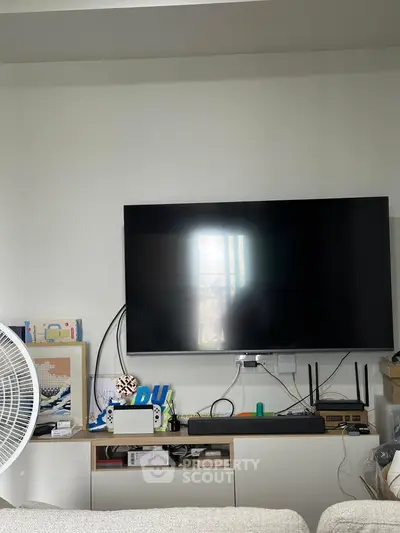 Modern living room with wall-mounted TV and gaming console setup