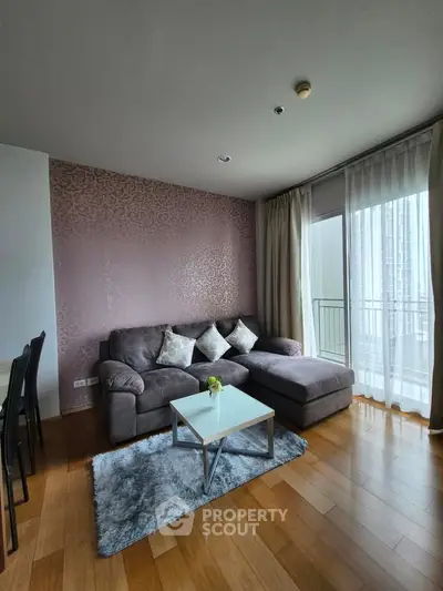 Modern living room with stylish decor and large windows offering natural light and city views.