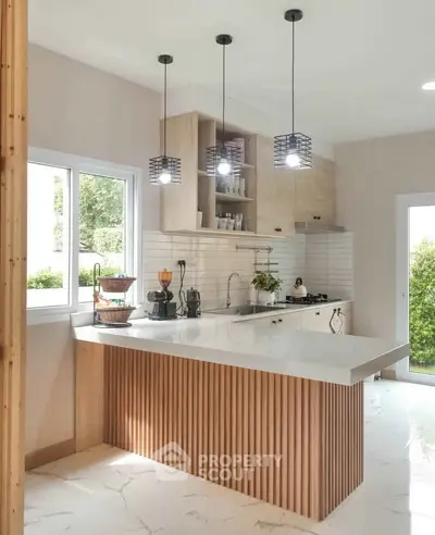 Modern kitchen with sleek design, featuring an open layout and stylish pendant lighting.