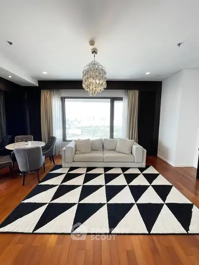 Elegant living room with modern decor, large window view, and stylish chandelier.