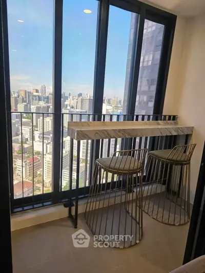 Stunning high-rise balcony with panoramic city views and modern seating area.