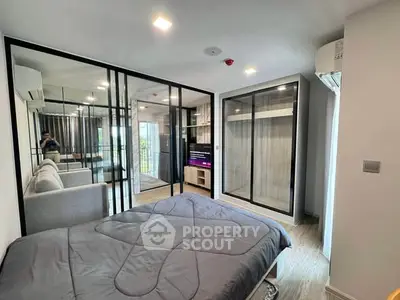 Modern bedroom with glass partition and stylish decor in a contemporary apartment.