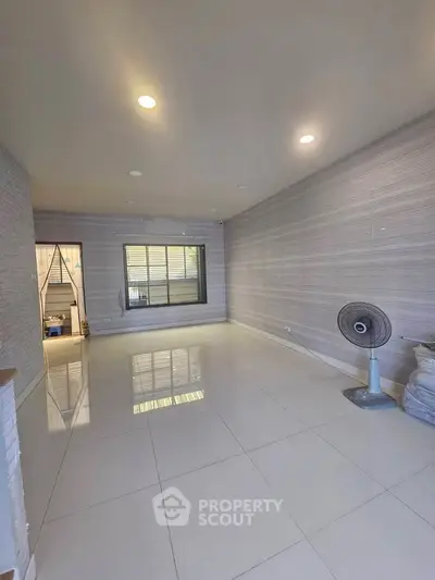 Spacious unfurnished room with tiled flooring and ceiling lights, ideal for customization.