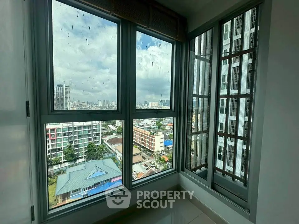 Stunning high-rise apartment corner unit with panoramic city view through large windows.