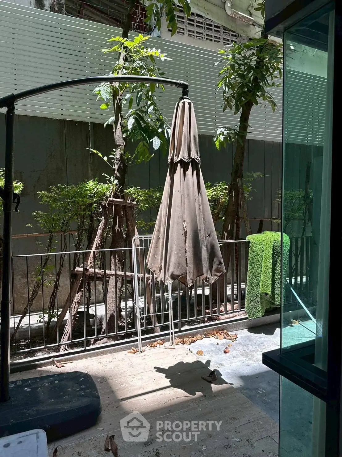 Charming garden patio with lush greenery and cozy outdoor seating area.