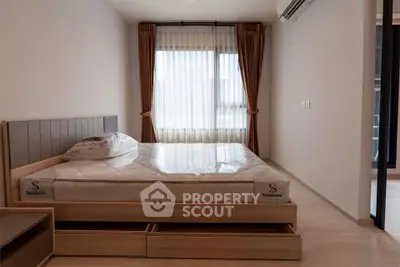 Modern bedroom with large window and stylish bed in a cozy apartment.