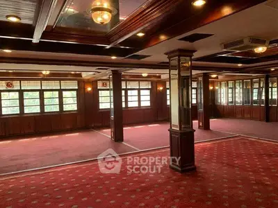 Spacious interior with elegant wood paneling and large windows, ideal for versatile use.