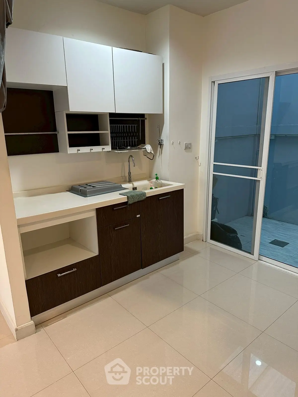 Modern kitchen with sleek cabinetry and sliding glass door to outdoor area.