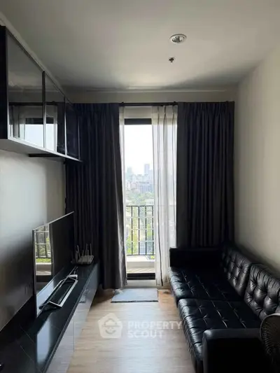 Modern living room with sleek black leather sofa and city view balcony.