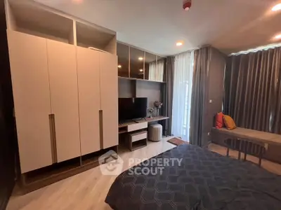 Modern bedroom with stylish decor and ample storage in a cozy apartment setting.