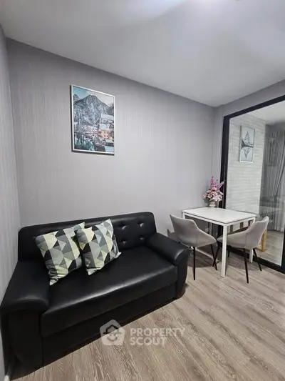 Modern living room with sleek black sofa and stylish dining area